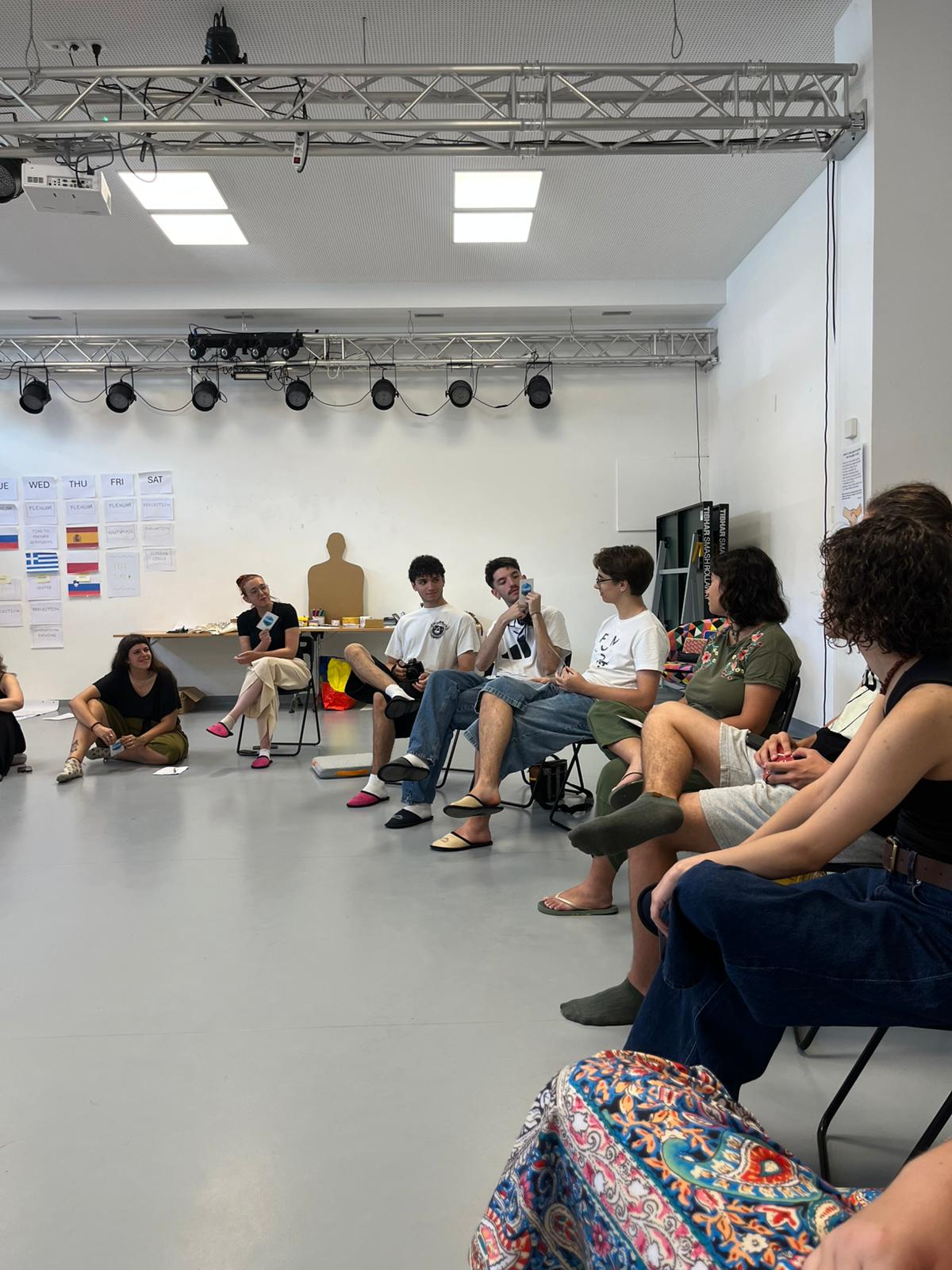 Plenary circle with microphones and studio lights during sharing session